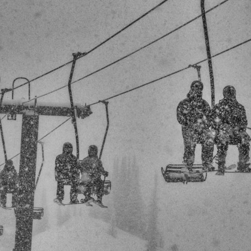 Skiier riding the chairlift in heavy blizzard conditions at Alta Ski Area in Utah.